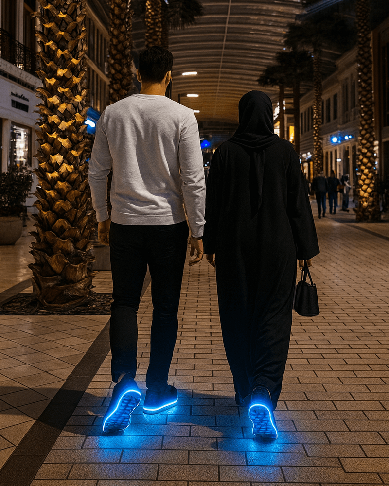 Two people walking on a sidewalk at night with glowing blue shoes، They wear comfortable Softy Steps shoe insoles.